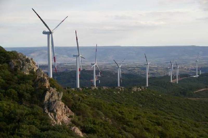 wind turbines on hill near city